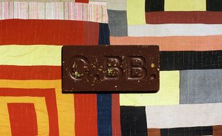 Casa Bosques Chocolates The Maker Series chocolate bar on background of art created by Mary L. Bennett