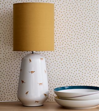 white wall with yellow dots yellow lamp with cheetah print pot white plates
