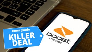 Boost Mobile logo shown on smartphone screen next to a laptop