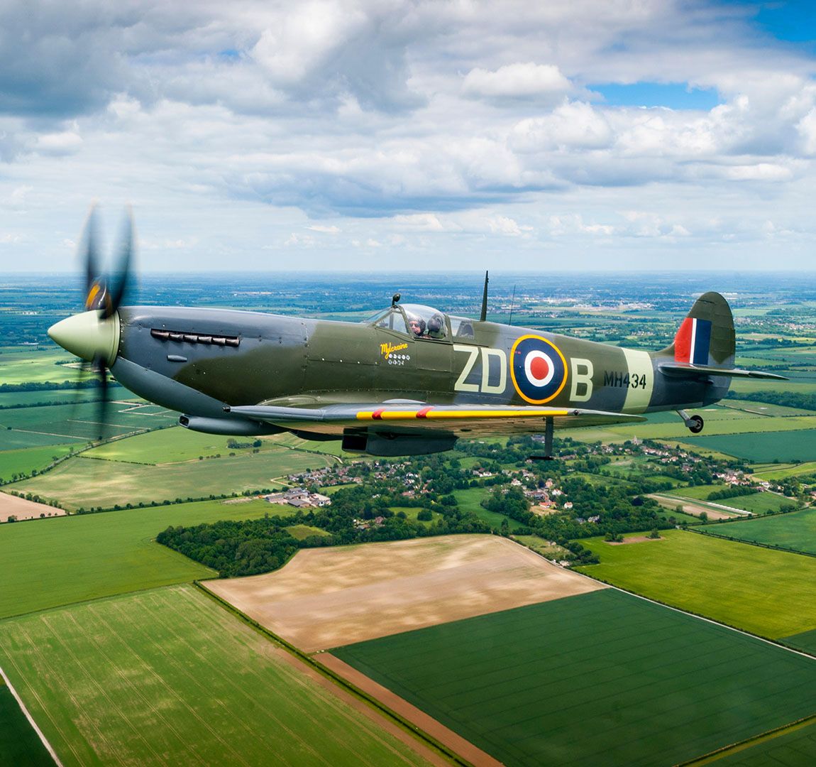 A Supermarine Spitfire Mark IX MH434 originally of 222 Squadron Royal Air Force, flying over the Cambridgeshire countryside near Duxford.