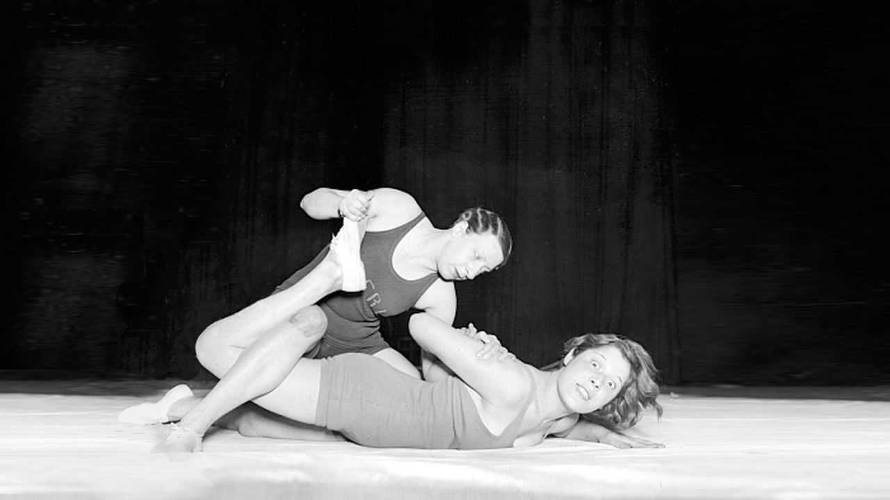 Black &amp; white photograph of man pinning woman down in wrestling hold