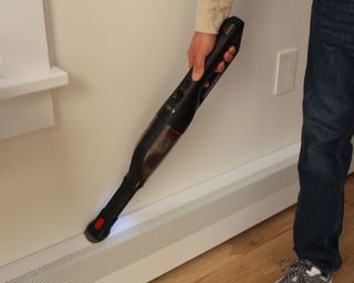 Camryn Rabideau using the Eufy HomeVac H30 vacuum on skirting boards