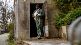 Assane (Omar Sy) leaving the cemetery with his dog, J'accuse in Lupin part 3 episode 2