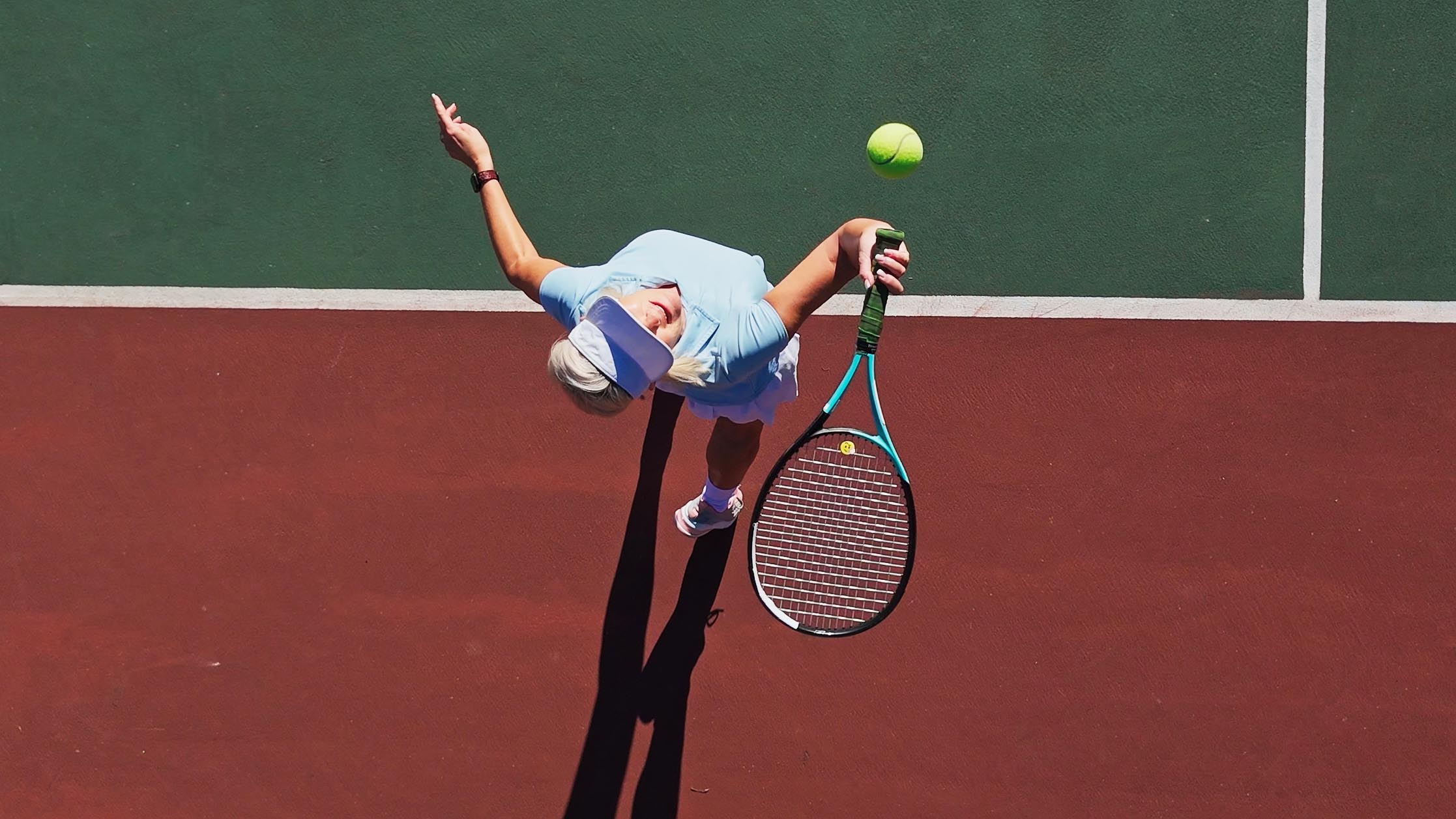 a senior woman playing tennis