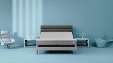 Sleep Number c4 mattress on a grey bedframe on a blue bedroom with blue nightstands, chair, sofa, and walls.