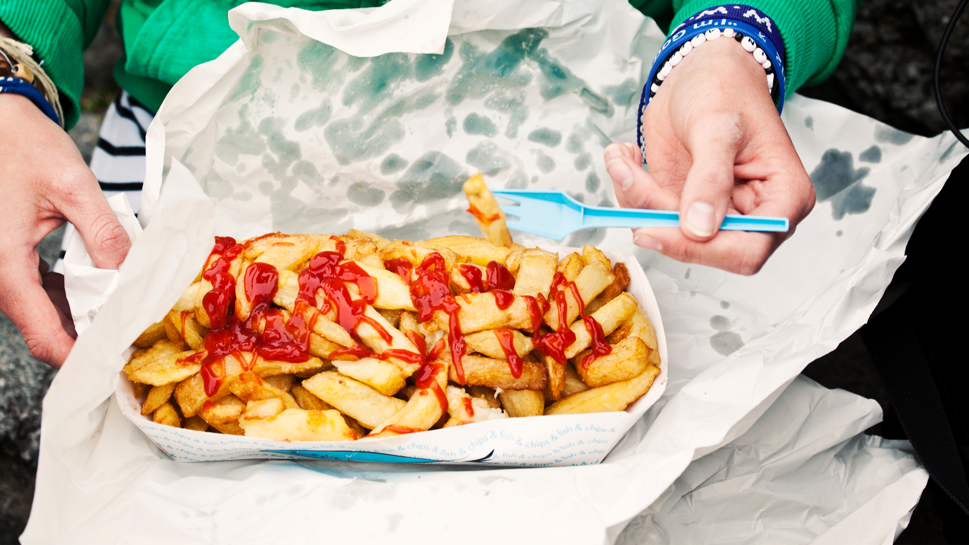 mujer comiendo papas fritas de un recipiente