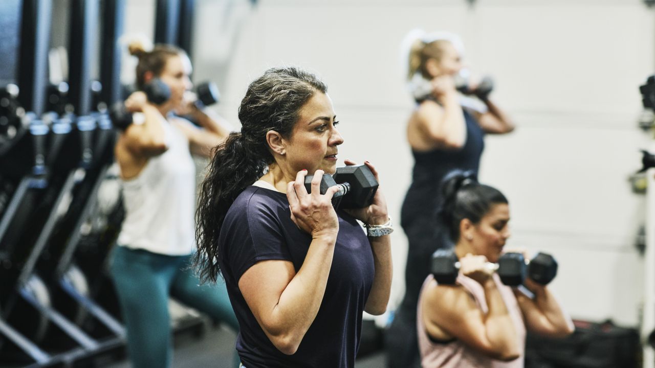 people doing dumbbell workout in a gym