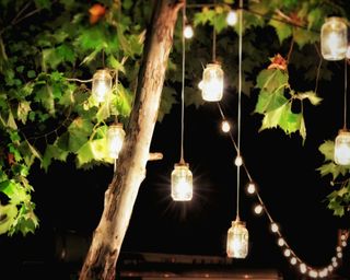 glass tea light lanterns hanging in tree