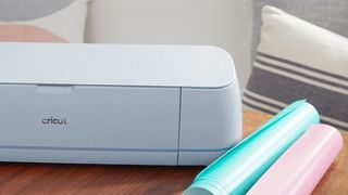 A photo of a Cricut cutting machine on a table with materials