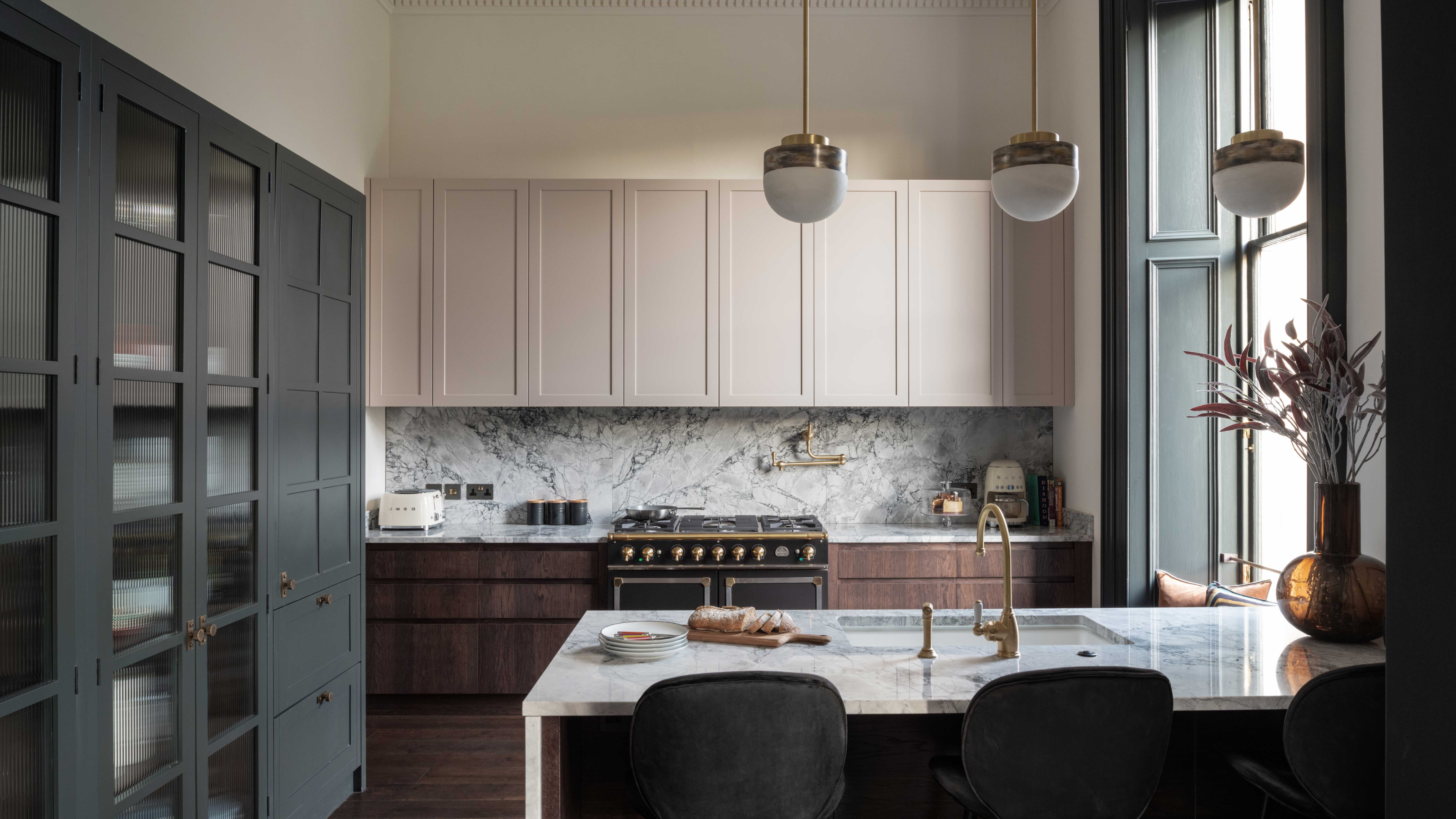 a mixed colored kitchen with dark gray cabinets, as well as pale pink and dark wood