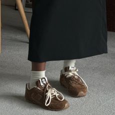 @nlmarilyn wearing brown Miu Miu X New Balance 530 trainers with white socks and a black skirt