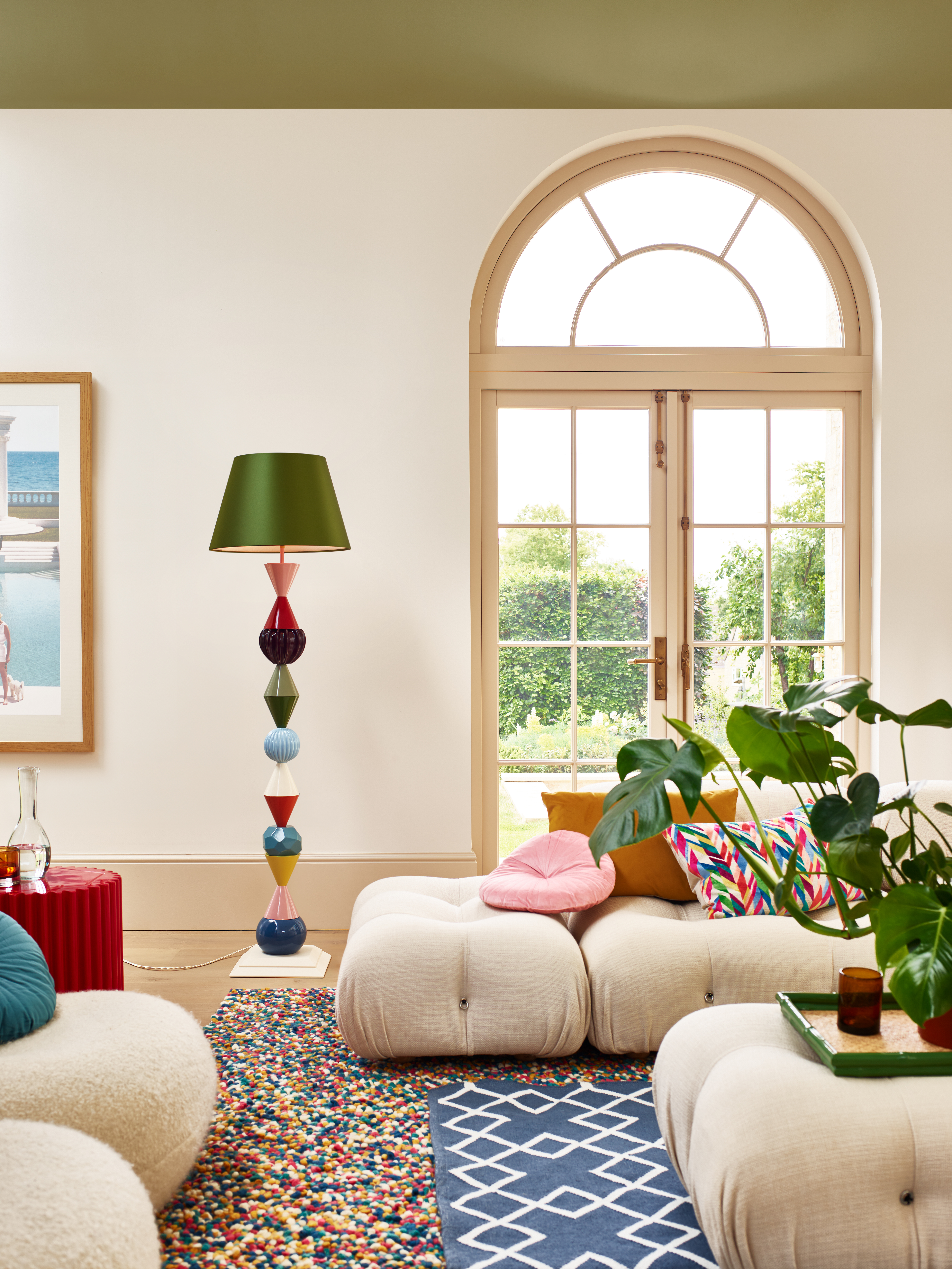 A neotenic living room with sculptural sofa and colorful floor lamp