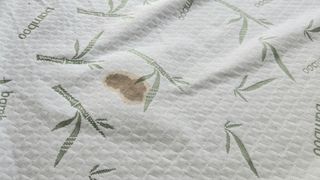 A close up of a brown coffee stain on the surface of the Utopia Bedding Bamboo mattress protector