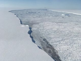 The edge of Larsen C Ice Shelf with the western edge of iceberg A68 in the distance