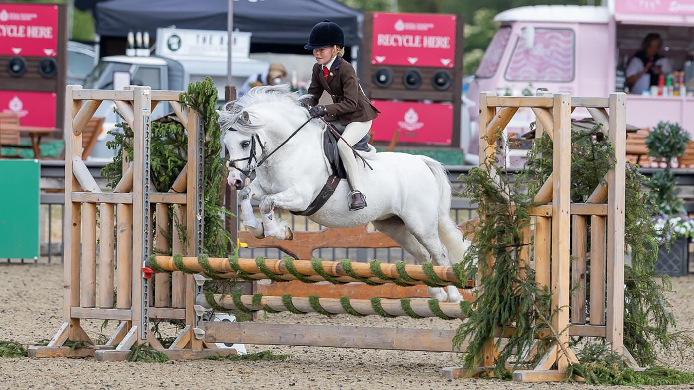 Poppy Rowlands and Delami Bravado on their way to winning the M&amp;amp;M working hunter pony class not exceeding 122cm at Royal Windsor Horse Show.