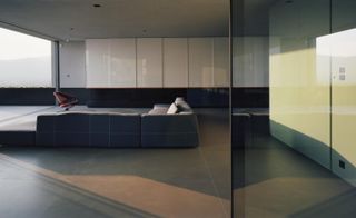 Sofa in minimalist interior at reflection house in Athens