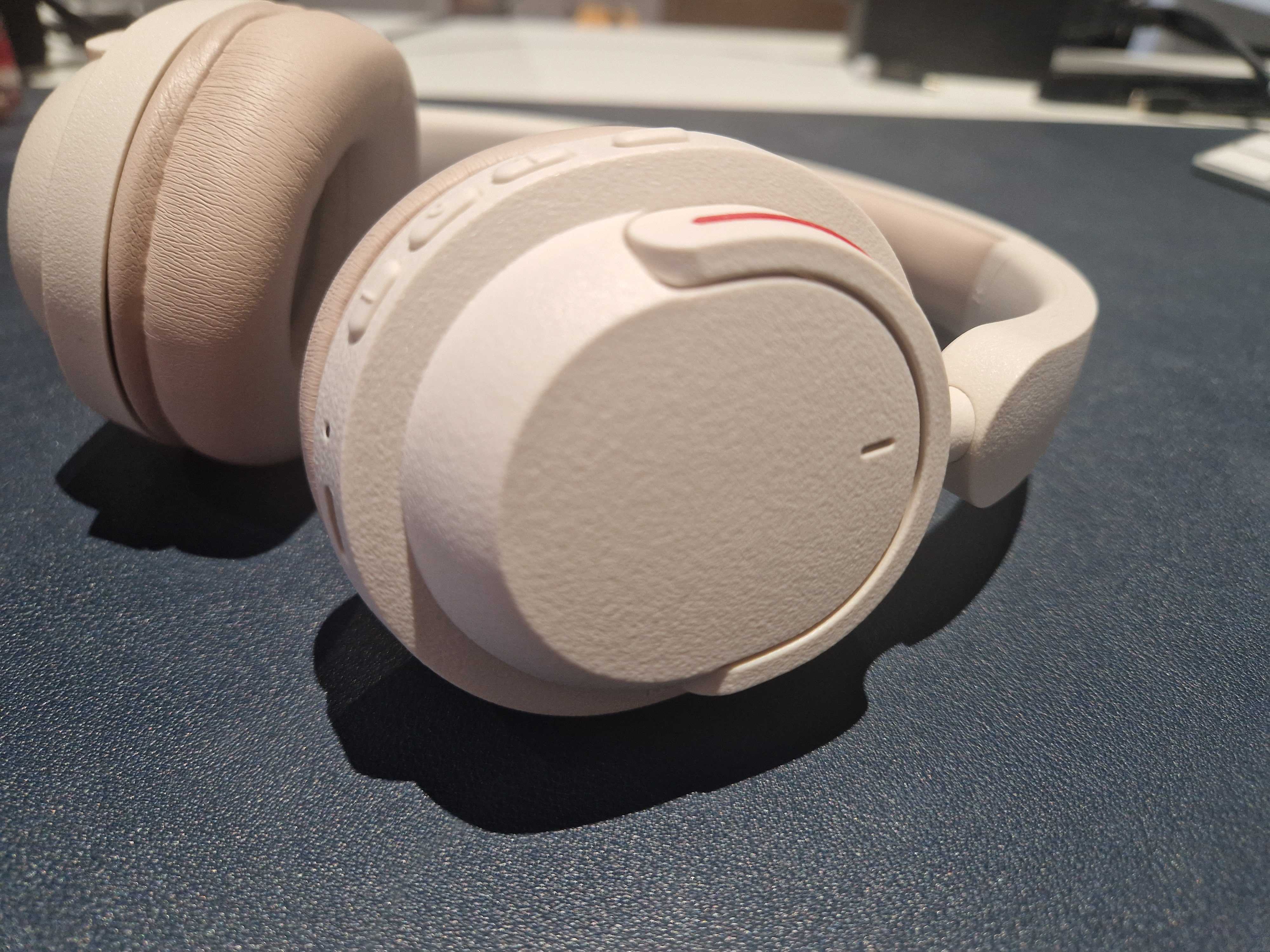 An off-white pair of BonoBeats Lite headphones sitting on a table