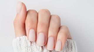 person's hand with square shaped white matte nails