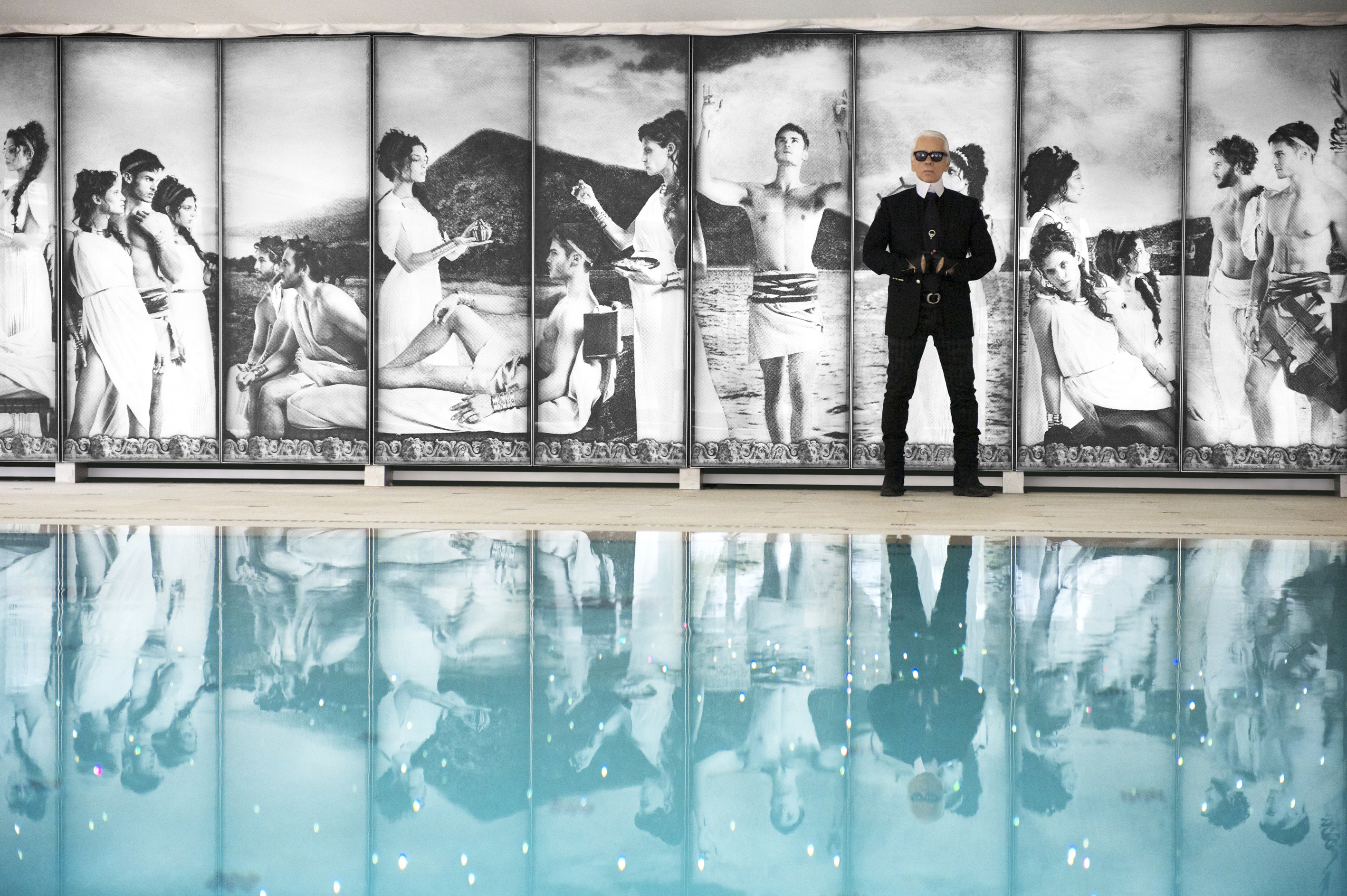 Karl Lagerfeld standing in front of a swimming pool