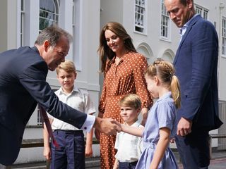 Prince George, Princess Charlotte and Prince Louis (C), accompanied by their parents the Prince William, Duke of Cambridge and Catherine, Duchess of Cambridge, are greeted by Headmaster Jonathan Perry as they arrive for a settling in afternoon at Lambrook School