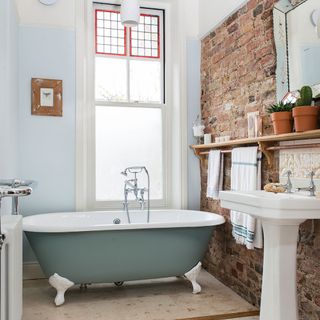 Bathroom with bathtub and brick wall