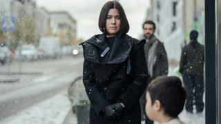 Smilla Jaspersen (Filippa Coster-Waldau) gazes at a child in the foreground, with Rahid Youseffi (Elyas M'Barek) in the background in Smilla's Sense of Snow