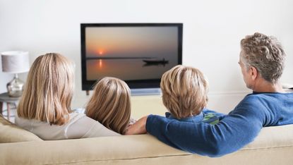 Mum, dad and two children watching TV