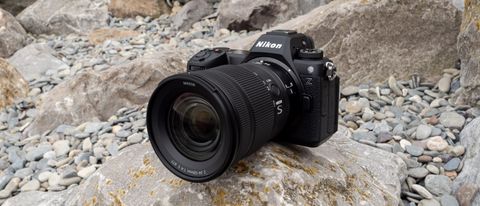 Nikon Z6 III sitting on a rock on a pebbly beach