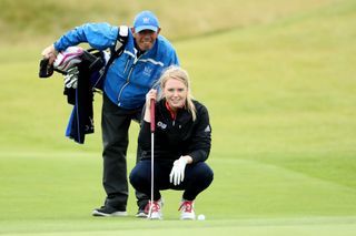 Anna Jackson lines up a putt with her caddie stood behind her