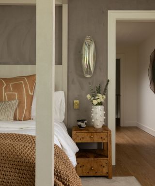 A neutral bedroom with a canopy bed and poster bed