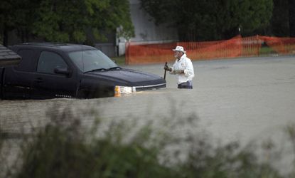 A man watches as a vehicle tries to navigate flood waters in Florence, S.C.