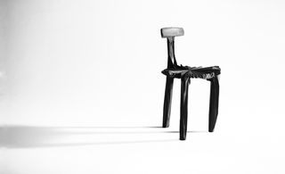 Three legged chair in dark wood
