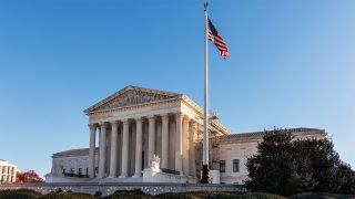 US Supreme Court with American flag flying in front