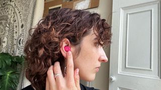 the author wearing the hot pink jlab jbuds mini earbuds