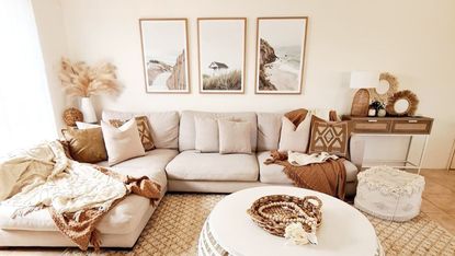Earthy neutrals in relaxed living room, with comfy chiase sofa, trio of coastal inspired wall art, and tactile, tasseled scatter pillows, throws and pouffe.