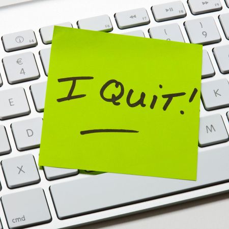 bright green sticky note reading &ldquo;I Quit&rdquo; on a computer keyboard