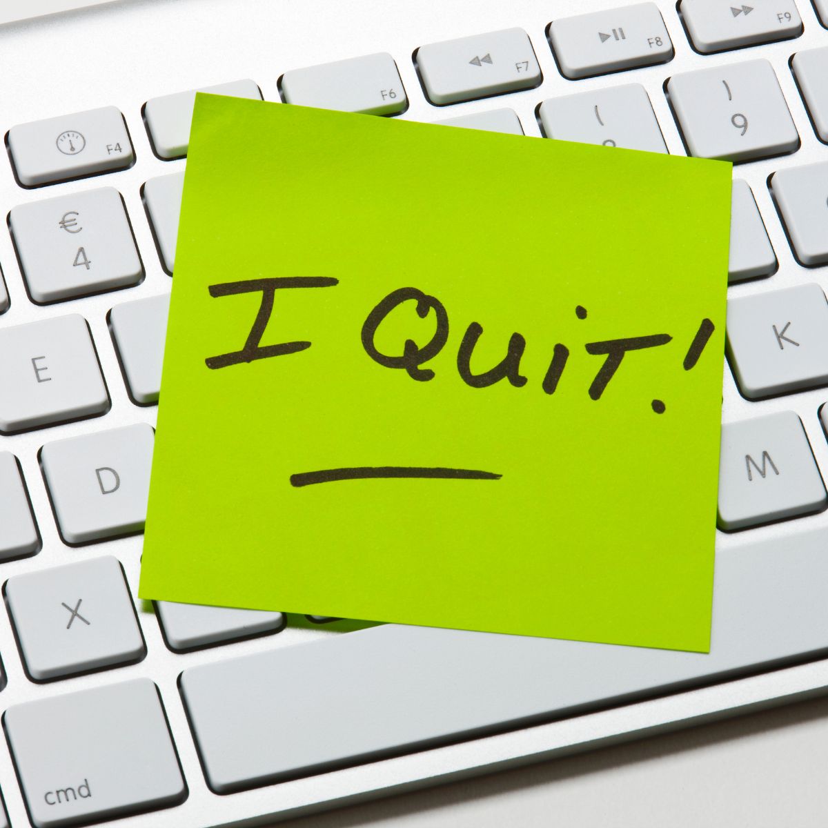 bright green sticky note reading &ldquo;I Quit&rdquo; on a computer keyboard