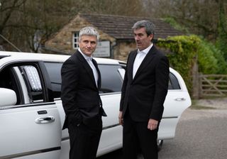 Caleb and Cain in suits next to a white limo