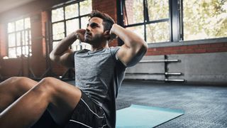 man doing a sit up at the gym