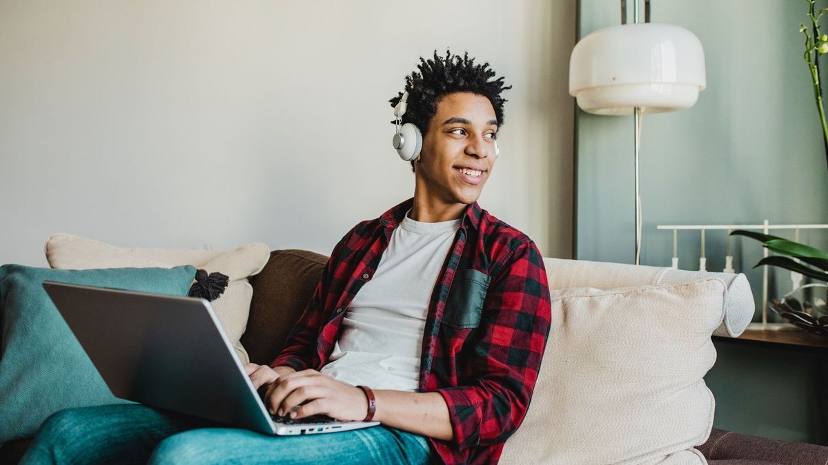 Student working on laptop with headphones