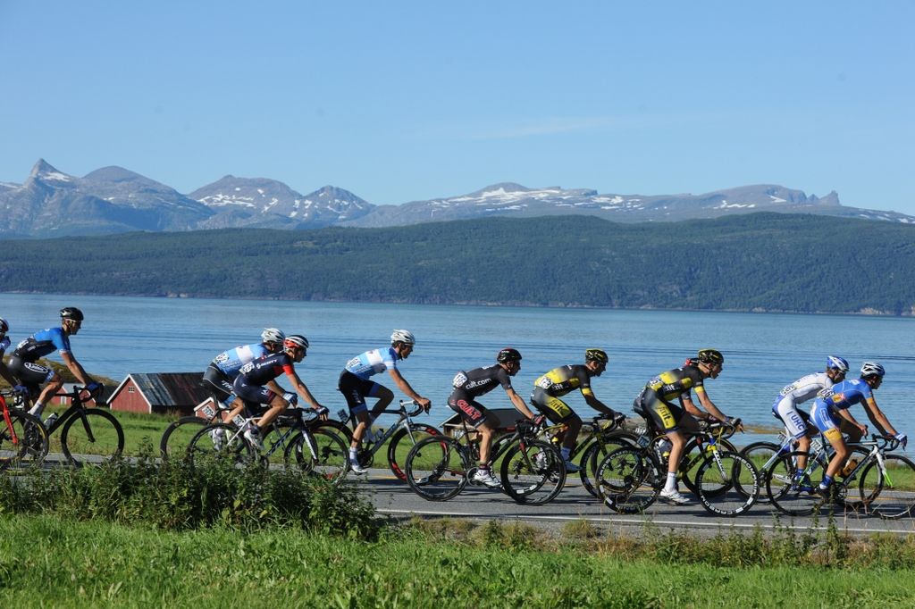 The peloton riders by a lake