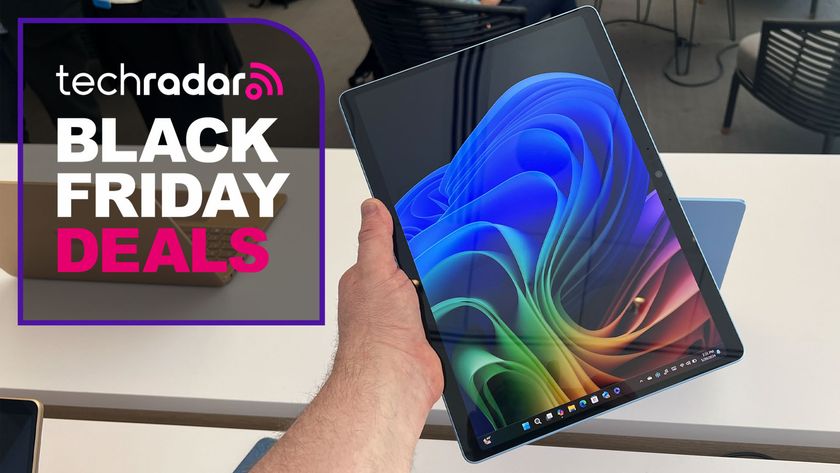 A masculine hand holding the Microsoft Surface Pro 11 with a TechRadar Black Friday deals overlay in the corner