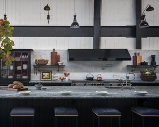 Grey and white kitchen ideas with a large grey island, white walls, black hood and beams
