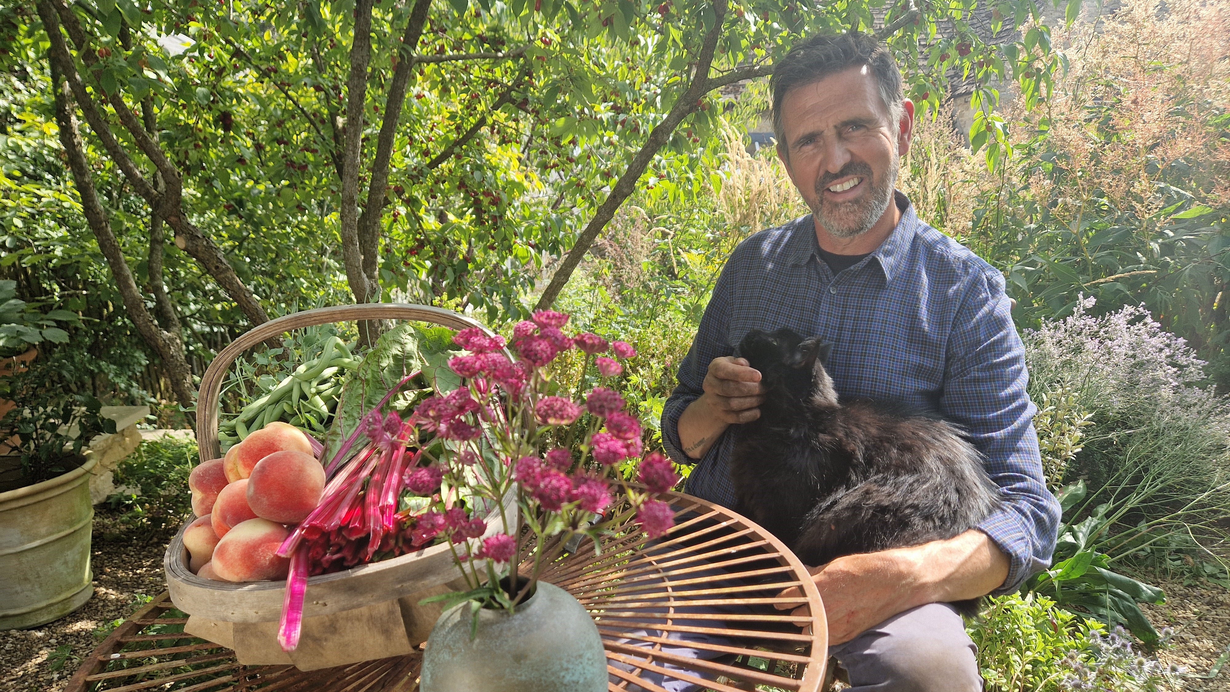 Adam Frost at home in his garden with Ash the cat