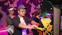 Gaming industry personnel Fengliang Shen plays 'Defender' during the E3 Video Game Convention at the Los Angeles Convention Center on June 11, 2019 in Los Angeles, California.
