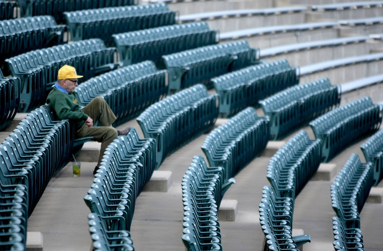 An old man sits alone in a stadium because there aren&amp;#039;t enough American people to fill it or our jobs