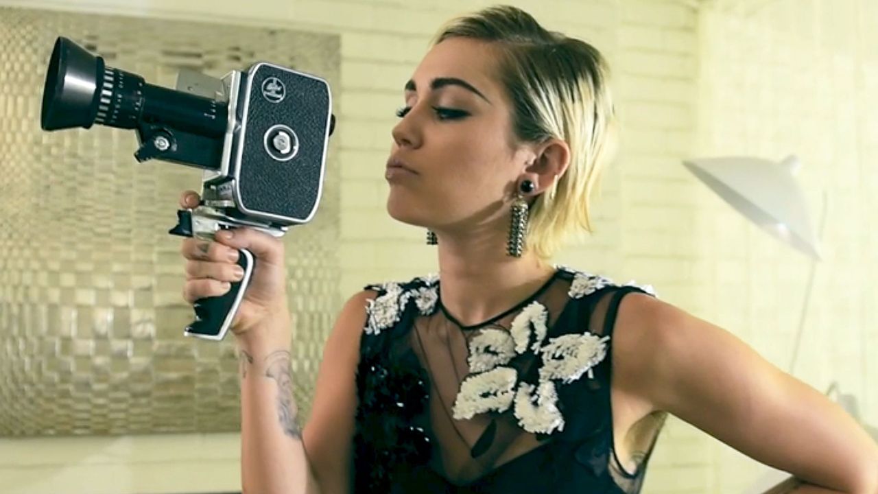 Miley Cyrus holding an old school video camera