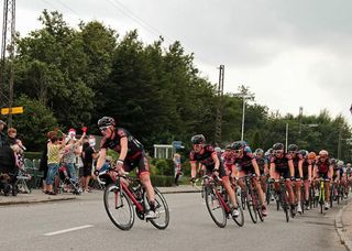 Team CULT Energy working in front of the chasing peloton to defend the yellow jersey