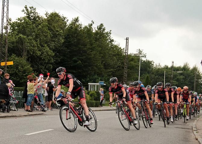 Team CULT Energy working in front of the chasing peloton to defend the yellow jersey