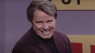 Phil Hartman grinning to the camera on SNL.
